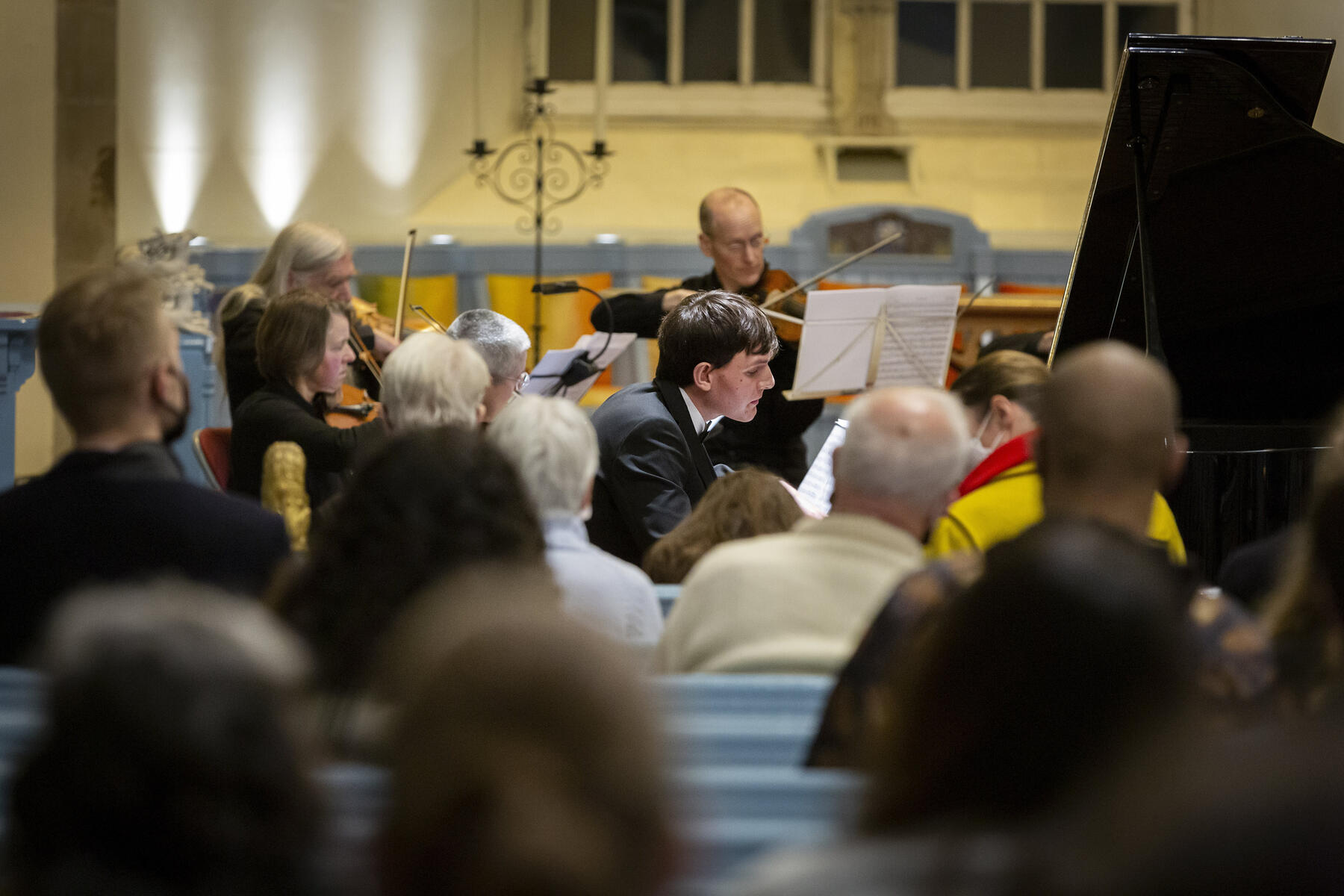 Matthew Shiel plays piano with an orchestra to an attentive audience